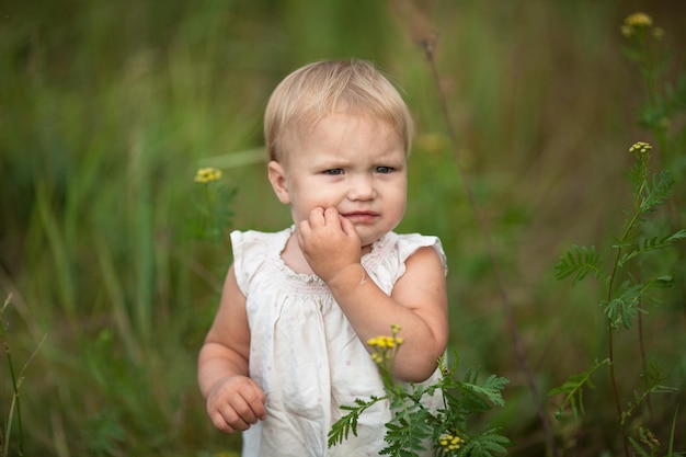 Il bambino del bambino cammina tra il concetto di erba infanzia e lo stile di vita della curiosità all'aperto