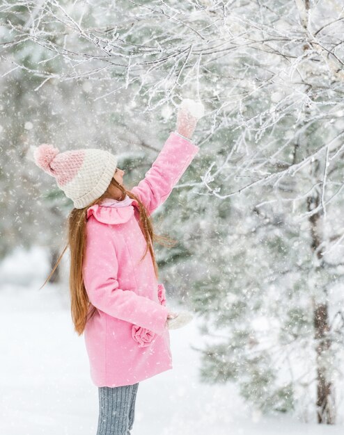 Bambino che tocca un albero, vista laterale