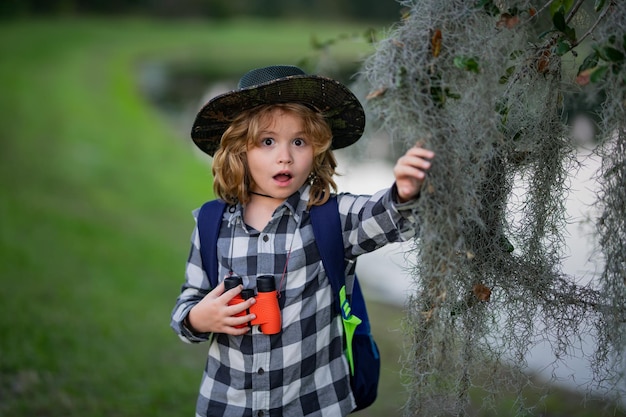 Child tourists with backpacks Adventure travel and tourism concept Kid walking with backpacks on nature Little explorer on trip