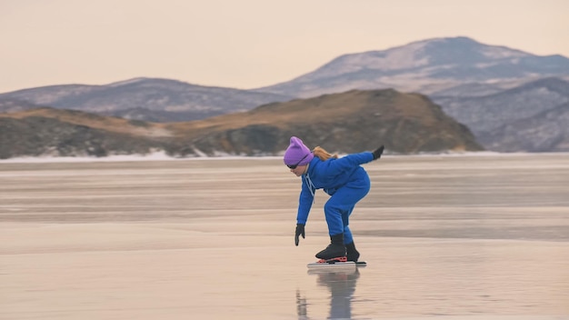 The child train on ice professional speed skating The girl skates in the winter in sportswear sport glasses suit Outdoor slow motion