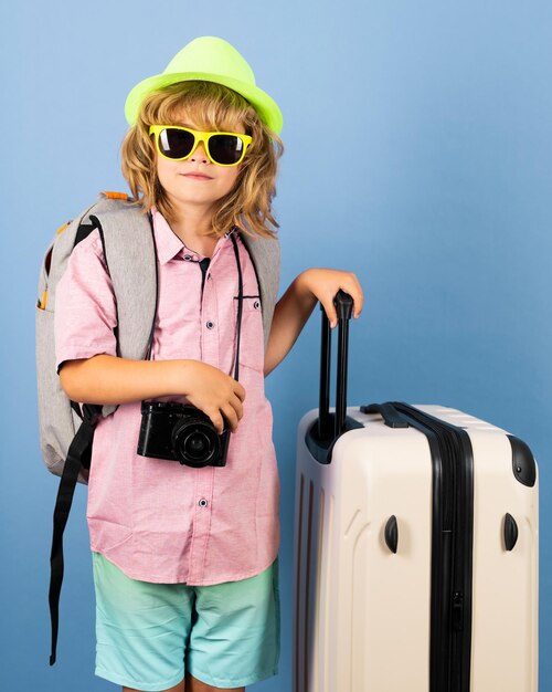 Child traveler with suitcase isolated on studio background Tourist kid boy Portrait of child travel with travel bag Travel adventure vacation