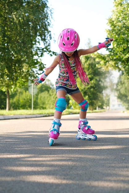 Photo child tries to keep his balance and not fall for the first time standing on roller skates