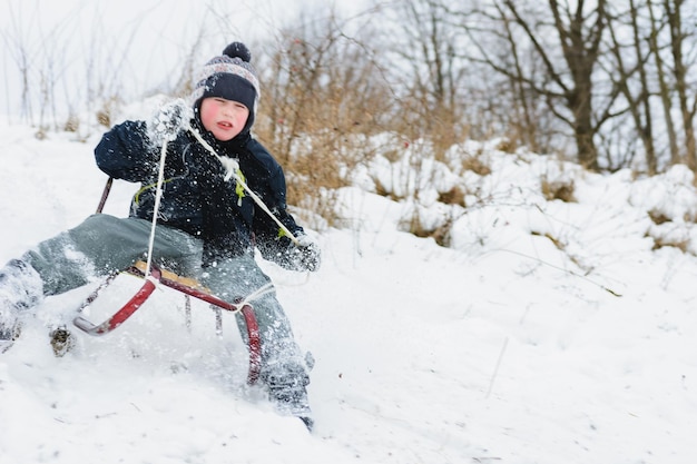 The child tries to stay in the sled so as not to fal