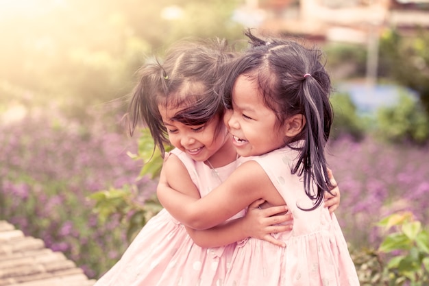 사진 아이 두 행복 소녀는 꽃밭에서 사랑으로 서로 포옹