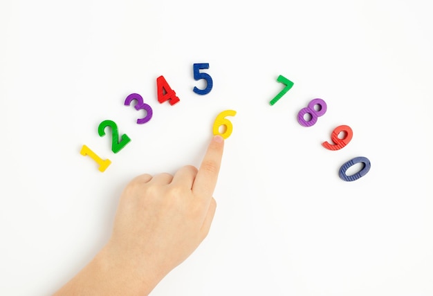 The child uses his index finger to move the number six up Early education We learn colors and count from zero to ten