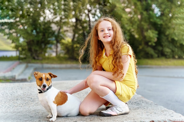Child walking with her puppy jack russell.
