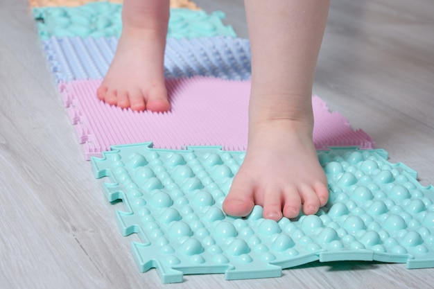 The child walks on the mat for massage of the feet at home