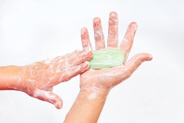 Ребенок моет руки с мылом крупным планом на белом фоне