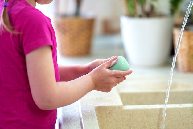 Child washes his hands with soap at home. concept of protection from viruses.