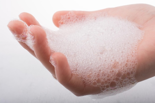 Child washing hands in foam