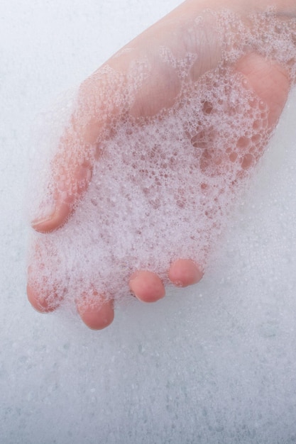 Child washing hands in foam