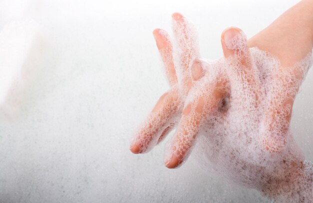 Child washing hands in foam