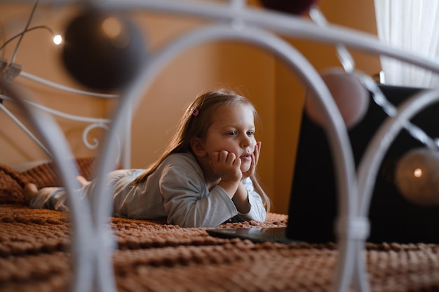 Child watching cartoons on the bed