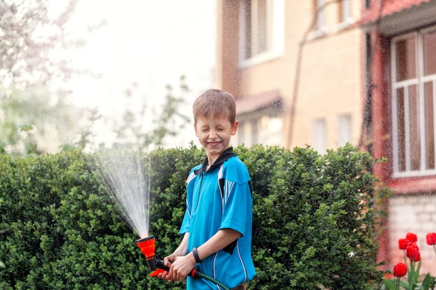 Child watering plants near the house