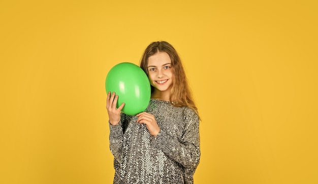 Child wear sparkling dress yellow background happy kid play with balloons balloons for birthday party colorful and bright surprise childhood happiness small girl hold party balloon