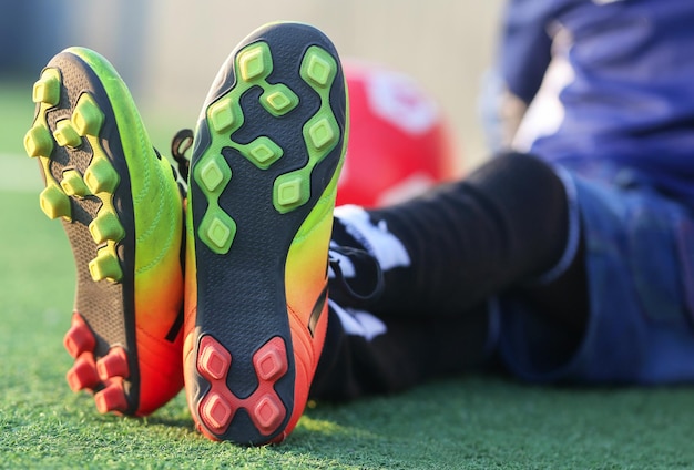 Bambino che indossa scarpe da calcio allenamento all'aperto