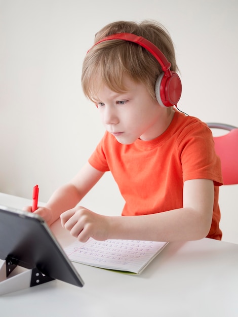 Photo child wearing headphones trying to understand the lesson