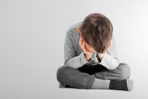 A child whose depression is sitting on the floor