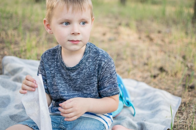 The child wipes his hands with a wet napkin