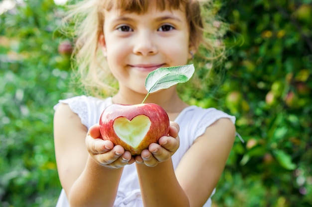 Child with an apple. Selective focus. Garden.