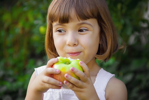 Child with an apple. Selective focus. nature