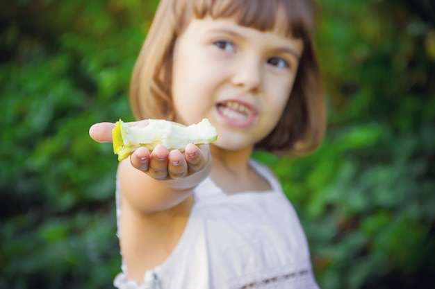 Bambino con una mela messa a fuoco selettiva natura