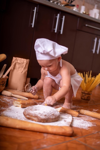 Foto bambino con il pane in mano vestito da cuoco