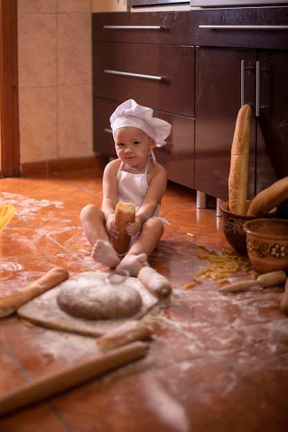 child with bread in his hands dressed as a cook