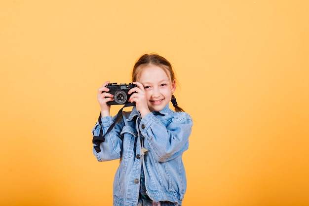 Child with camera on yellow