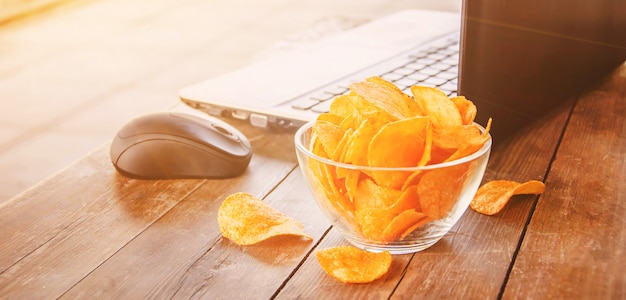 Photo child with chips behind a computer. selective focus.