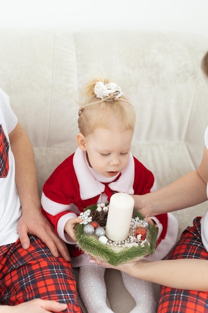 Child with cochlear implant hearing aid having fun with parents in christmas living room diversity deafness treatment and medical innovative technologies