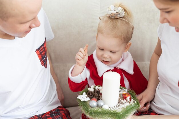 Child with cochlear implant hearing aid having fun with parents in christmas living room diversity deafness treatment and medical innovative technologies