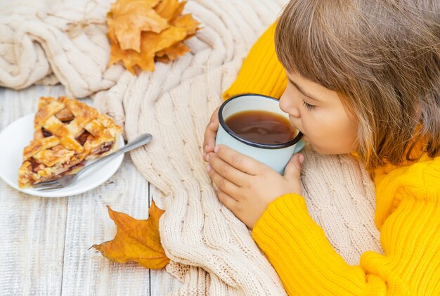 彼の手でお茶を一杯持つ子。