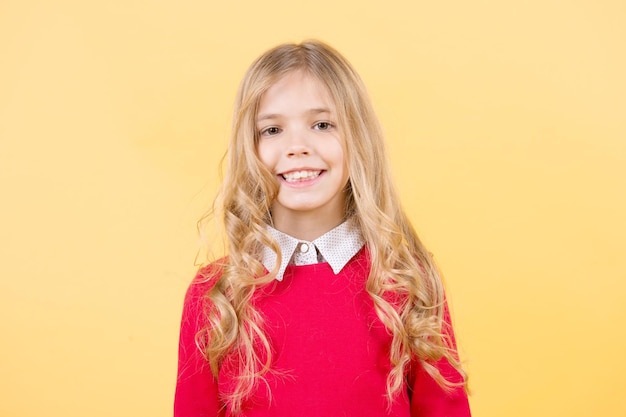 Child with curly blond hair in red sweater