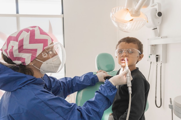 A child with a dentist in a dental office. Dental treatment in a children's clinic.