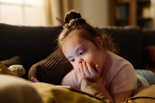 障害のある子供がソファでリラックスしている