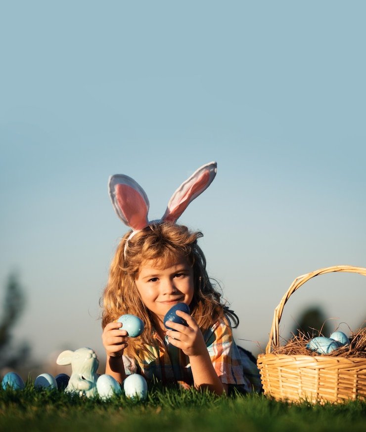 Photo child with easter eggs in basket outdoor boy laying on grass in park on sky background with copy spa