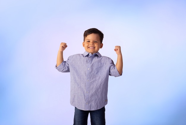 Child with facial expressions in a studio photo over colored background.