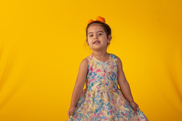 Child with facial expressions in a studio photo over colored background.