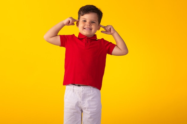 Bambino con le espressioni facciali in una foto in studio su sfondo colorato.