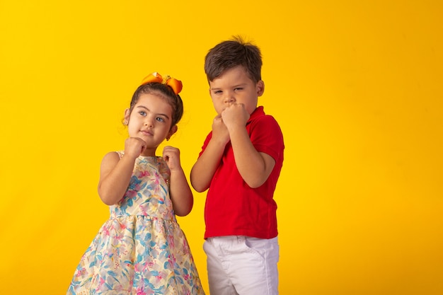 Child with facial expressions in a studio photo over colored background.