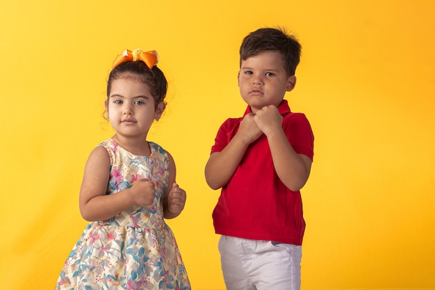 Child with facial expressions in a studio photo over colored background.