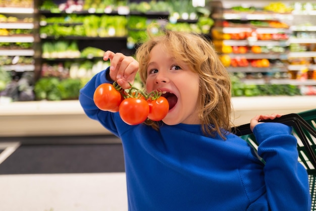 Child with fresh tomato vegetables healthy food for kids portrait of smiling little child with shopp