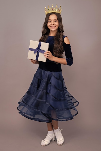 Child with gift present box on isolated background presents for\
birthday valentines day new year or christmas happy face positive\
and smiling emotions of teenager girl