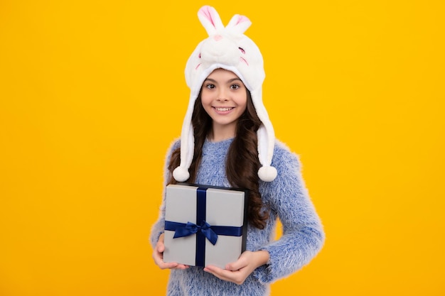 Child with gift present box on isolated background presents for\
birthday valentines day new year or christmas happy teenager\
positive and smiling emotions of teen girl