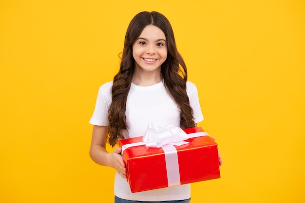 Child with gift present box on isolated background presents for\
birthday valentines day new year or christmas happy teenager\
positive and smiling emotions of teen girl