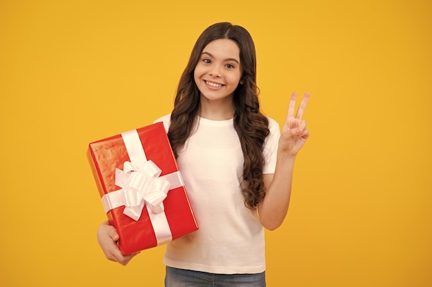 Child with gift present box on isolated background Presents for birthday Valentines day New Year or Christmas Happy teenager positive and smiling emotions of teen girl
