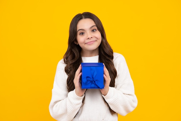 Child with gift present box on isolated studio background Gifting for kids birthday Happy face positive and smiling emotions of teenager girl