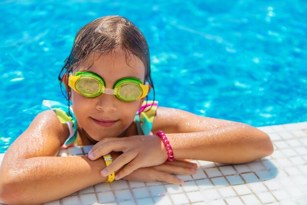 A child with glasses dives into the pool. Selective focus.