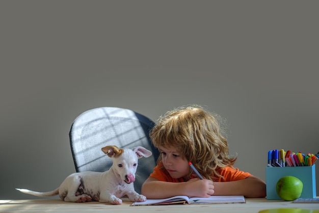 Child with her pet puppy friend Children and pet education concept pupil writing to notebook at home